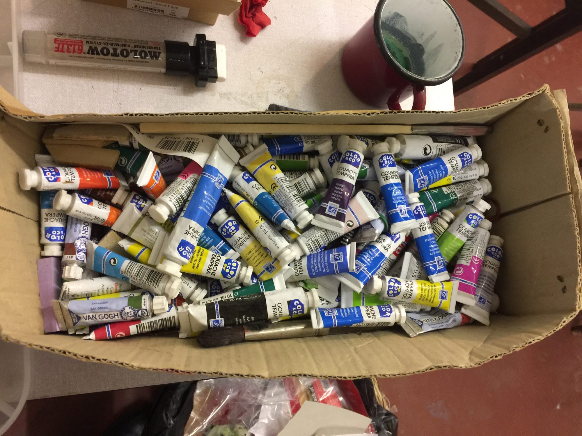 tubes of paint in a cardboard box